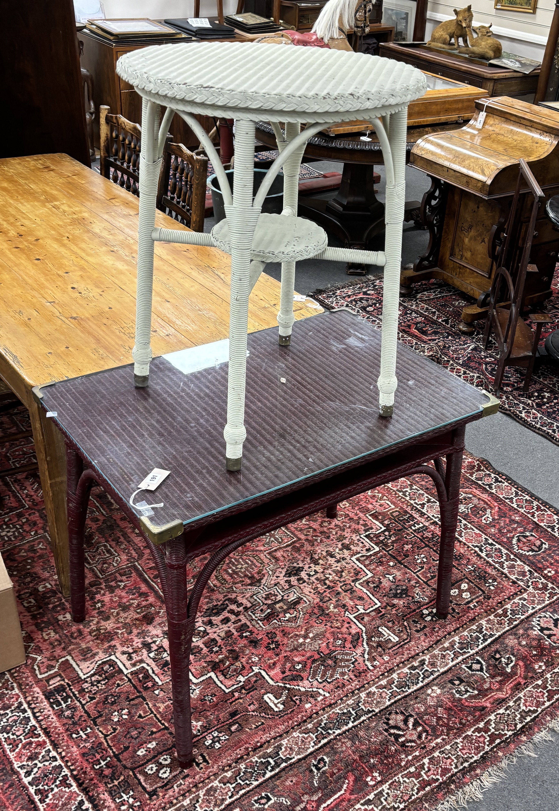 A Lloyd Loom rectangular table, width 91cm, depth 61cm, height 73cm together with a smaller circular Lloyd Loom table